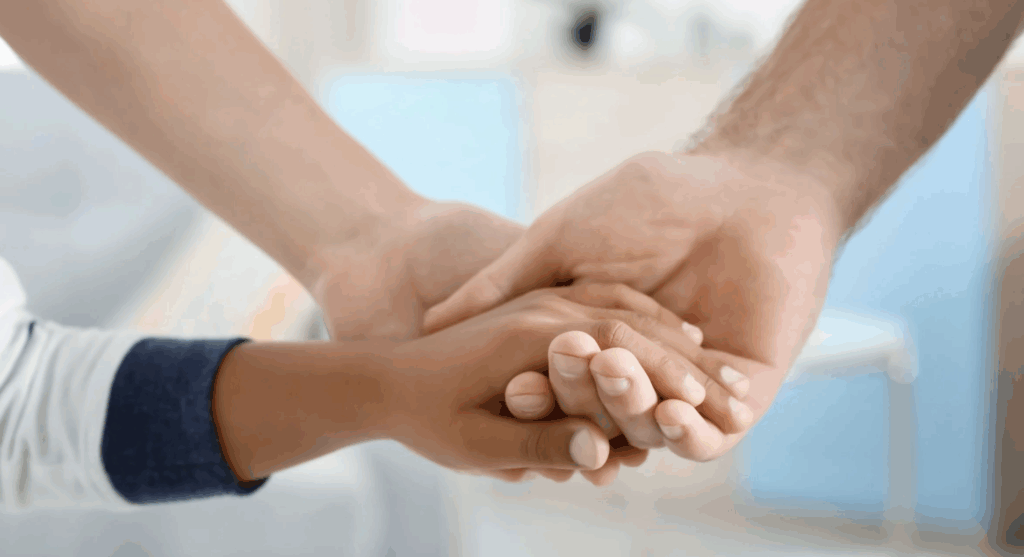 Hands of diverse individuals clasped together, symbolizing connection and support in the adoption journey.